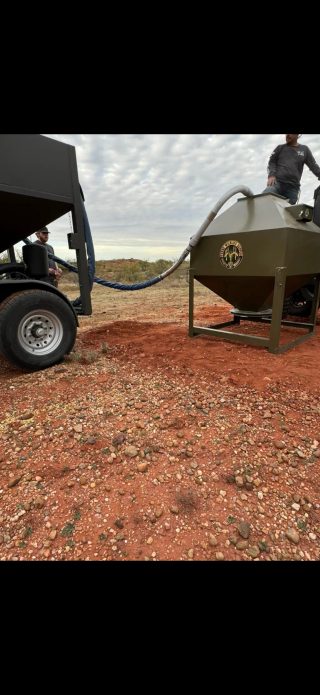 BarBell Ranch staff filling a feeder in Sweetwater, TX.