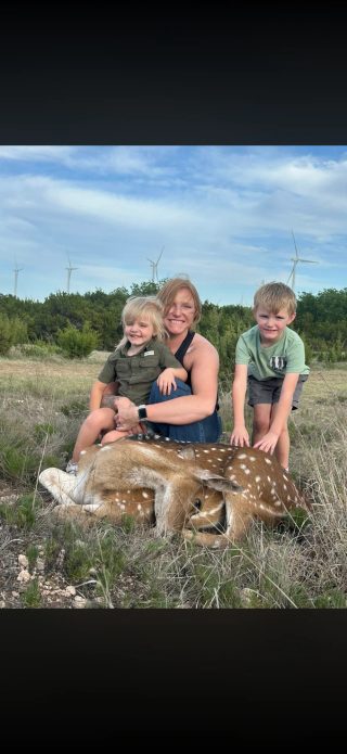 A hunter and two children with an Axis doe taken at BarBell Ranch in Sweetwater, TX.
