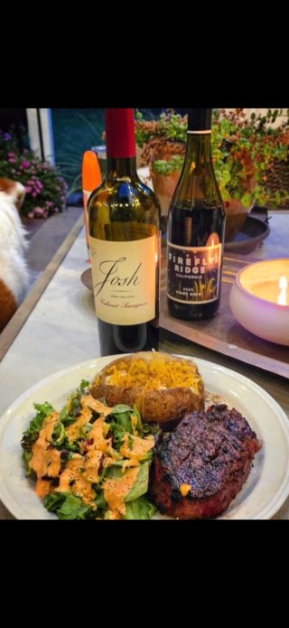 A grilled steak dinner with salad and baked potato, served with red wine at BarBell Ranch in Sweetwater, TX.