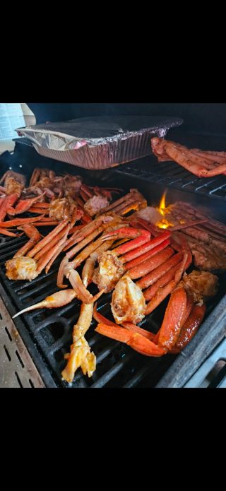 Crab legs grilling with a foil pan, part of the unique experience with lodging at BarBell Ranch.