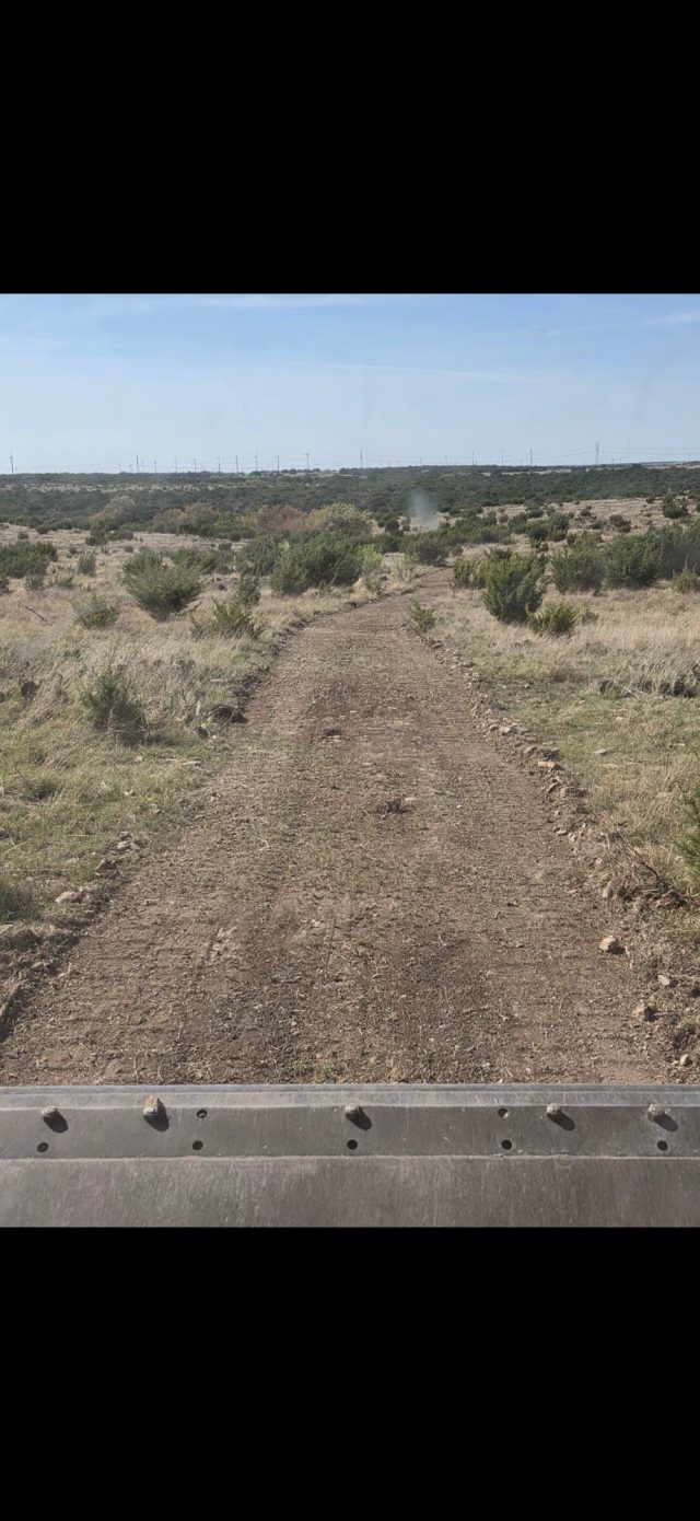 Texas hunting ranch road winding through West Texas brush country.