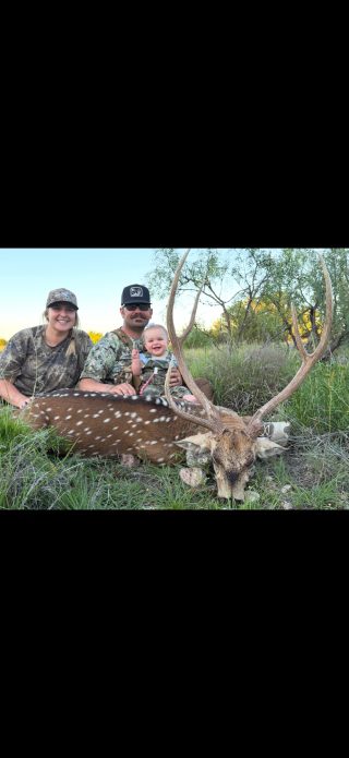 An Axis buck and a happy family at BarBell Ranch in Sweetwater, TX.
