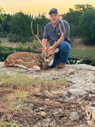 Hunter with a harvested Axis buck taken at BarBell Ranch in Sweetwater, TX.