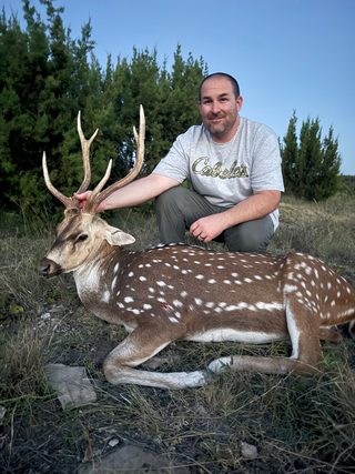 A hunter poses with his Axis buck taken at BarBell Ranch in Sweetwater, TX.